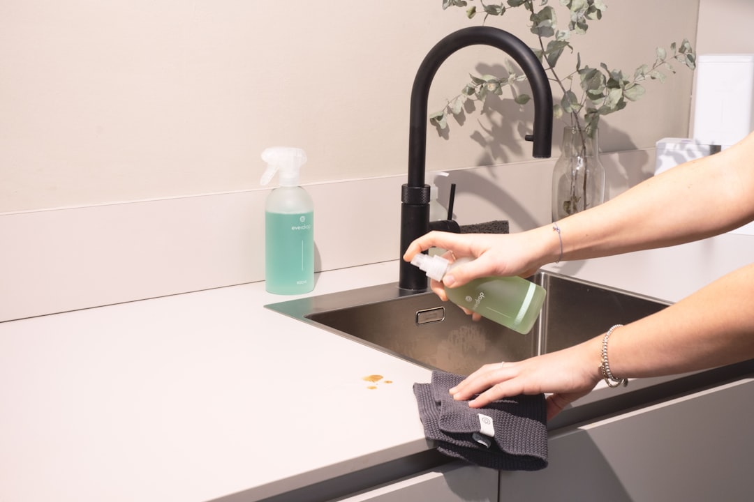 mobile-02 a-woman-is-cleaning-a-kitchen-sink-with-a-rag-sqomdoqb3ws